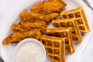 Crispy fried chicken tenders with a golden Belgian waffle at Hungry Jack's in Crosby, TX—serving authentic comfort food to the North East Houston and Lake Houston area."